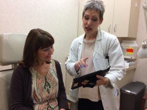 Dr. Travers explains new EMR system to patient