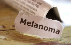 Word Melanoma cut out from a newspaper