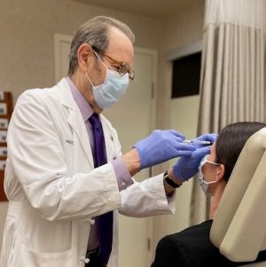 Dr. Arndt injecting Botox to patients forehead