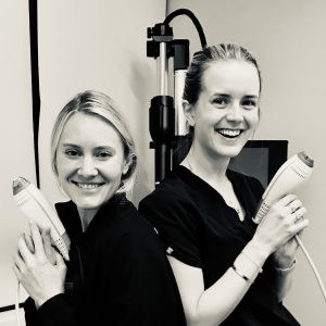 Dr. Halgstrom and Dr. Jessica Labadie back-to-back, each holding a Clear+Brilliant deviceing