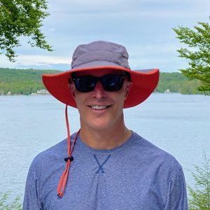 Dr. Rohrer wearing a wide-brimmed hat, sunglasses, and SPF clothing