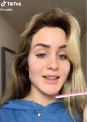 Teenage girl demonstrating teeth filing on TikTok