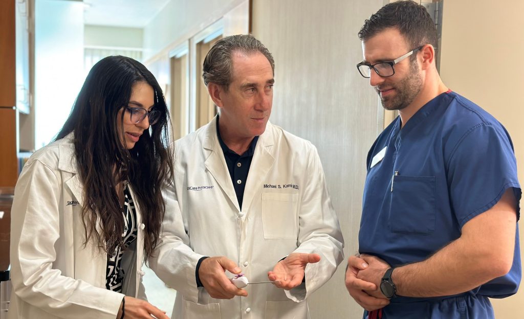 Dr. Kaminer explaining the Aveli cellulite device to two Fellows