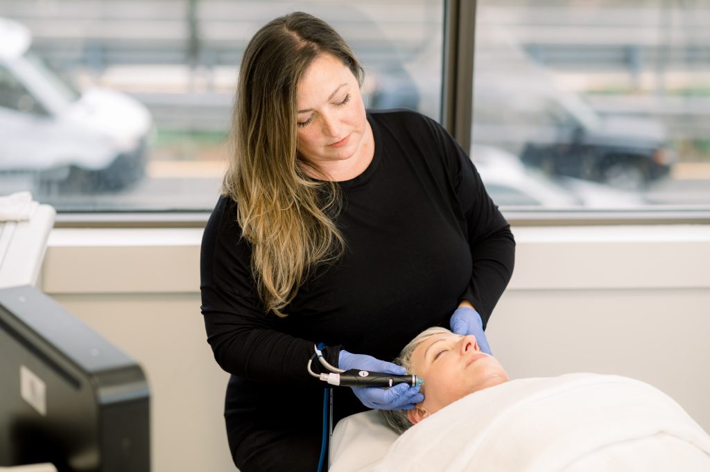 SkinCare Physicians' aesthetician giving an Hydrafacial treatment to a patient